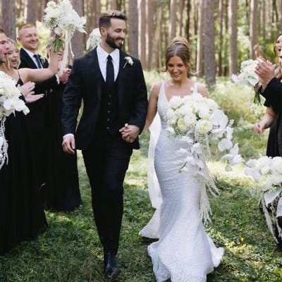 Bride and groom walk back down wooded aisle 