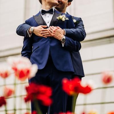 Zach and Clay Embrace Amidst the Flowers on their Wedding Day at The Madison Club