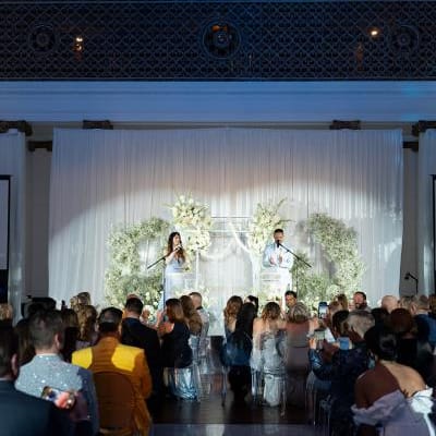 Guests seated at 440 Elm watching the California Wedding Day Best of 2025 ceremony hosted by Weddings Royale in front of a floral installation