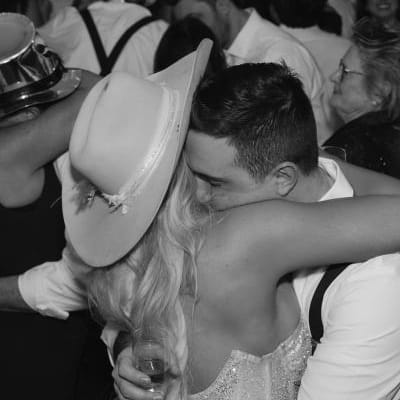 Bride and groom embrace in a hug, depicted in black and white