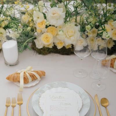Butter yellow tablescape featuring lush florals and croissant details at Zenia