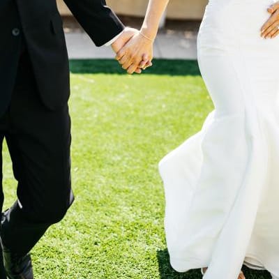 Bride and groom holding hands against the grounds of Omni Scottsdale Montelucia