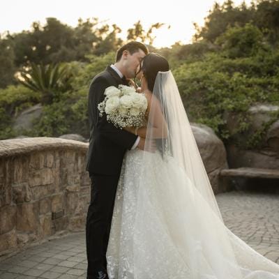 Bride and groom share a kiss during golden hour on grounds of Villa Loriana