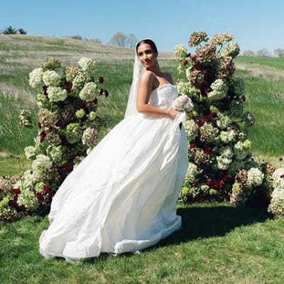 Model poses in front of enchanting altar comprised of monochromatic florals on the expansive grounds of Selmer + Stone