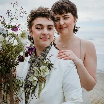 Close up of couple posing, one standing behind the other, in intimate elopement on Cannon Beach