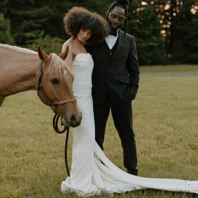 Models pose with a light brown horse on the grounds of Wind Mountain Ranch