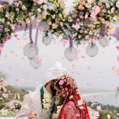 Bride and groom embrace under lush mandap at Malibu Seaview Estate