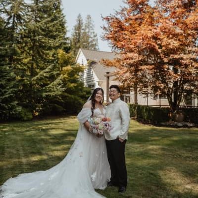 Bride and groom pose with bright foliage in the backdrop at Rock Creek Gardens