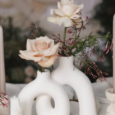Sculptural stone vase holding two roses in imagined reception design