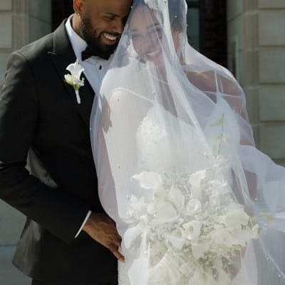 Bride and groom stand close together in an embrace on their wedding day