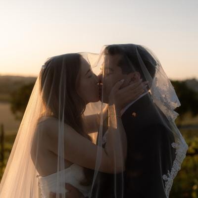 Bride and groom share a kiss on the grounds of Hearst Ranch Winery during golden hour