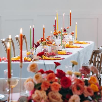 Vibrant tablescape featuring juicy hued florals, fruit accents and taper candles at Woodhaven
