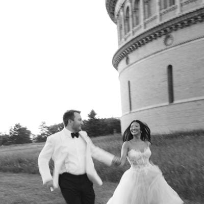 Bride and groom frolick through the grounds outside of Yerkes Observatory hand in hand on their wedding day