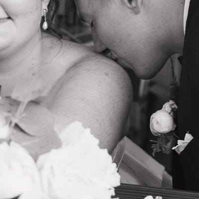 Close up of groom kissing bride's shoulder in wedding day at Mercantile Hall