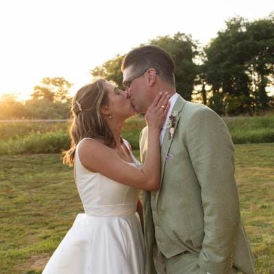 Bride and groom share a kiss during golden hour-lit reception at Hawk Creek Gallery