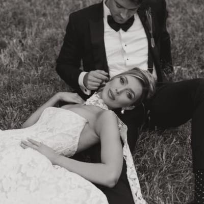 Bride rests her head on the groom's lap on their wedding day at Woods & Co.