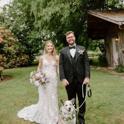Bride and groom pose with their dog on their wedding day at Woodland Meadow Farms