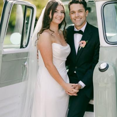 Bride and groom pose next to retro truck in wedding day at Cavalli Estates
