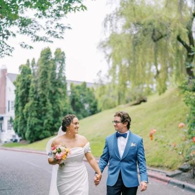 Bride and groom hold hands walking together on their wedding day at Teh Admiral's House