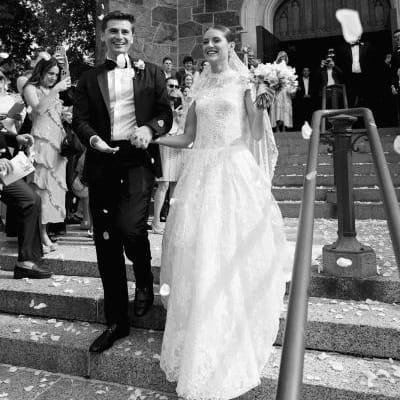 Isabel and John descend the staircase after ceremony t Plymouth Congregational Church as petals waft through the air