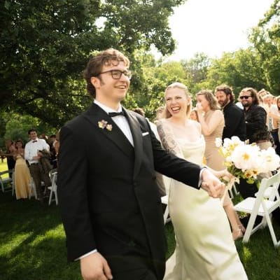 Addie and Walker beam as they walk down the aisle after exchanging I do's at Mayowood Stone Barn