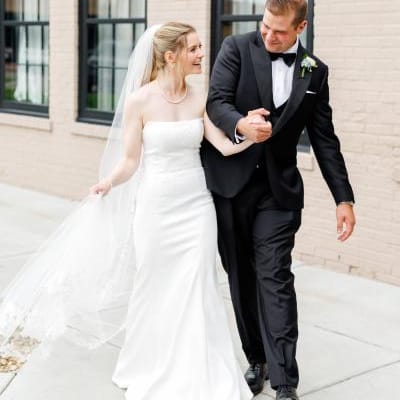 Colette and Dylan walk outside of The Confluence Hotel on their wedding day