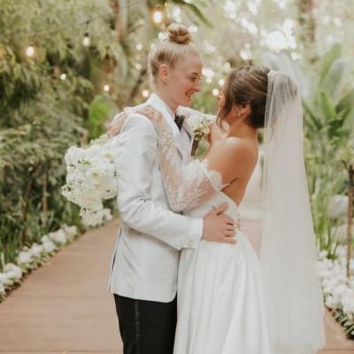 Taylor and Summer embrace on the grounds of Botanica on their wedding day