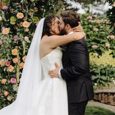 Valeria and Benjamin share a kiss at their floral-filled altar at Kiana Lodge