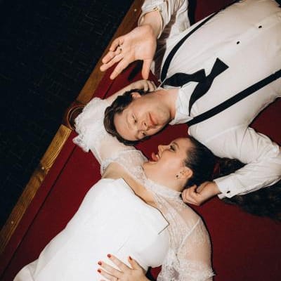 Lauren and Drew pose laying on the ground facing each other at Le Veneré