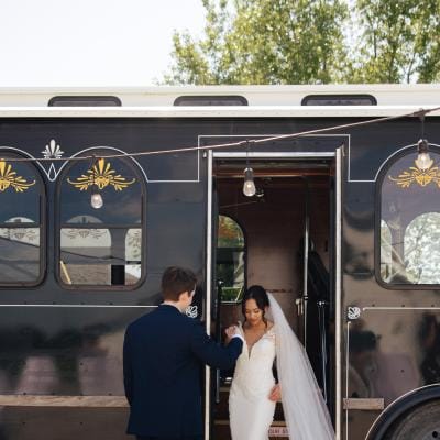 Chonhanh and Nicholas pose on the steps of their wedding day trolley