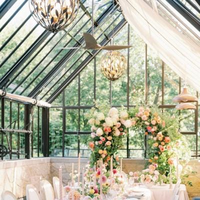 Greenhouse reception dinner featuring designer tableware and lush florals