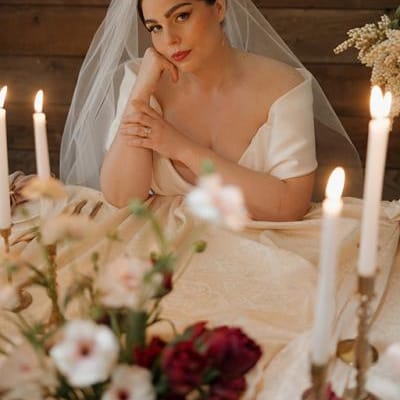 Model poses sat at staged reception table at Abbey Road Farms