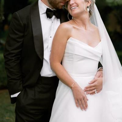 Sophie and Andrew pose side by side in their wedding attire