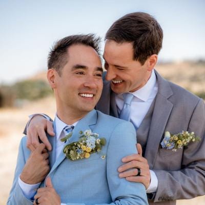 Jonathan and Robbie pose in a warm embrace on their wedding day