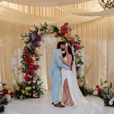 Danielle and Brandon share a kiss at the indoor floral altar