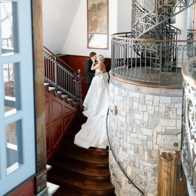 Lindsey and Scott pose on the staircase of Chateau de Harpe