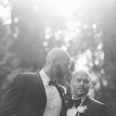 Zach and Bryce pose in their ceremony attire, in black and white
