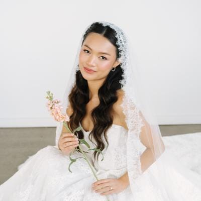 Model poses in ballgown with flowers in hand