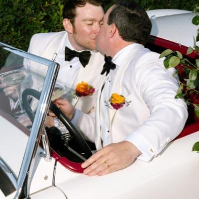 James and Timmy share a kiss in their floral decorated vintage getaway car