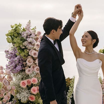 Groom spins bride on lush altarspace platform on their wedding day at Montage Laguna Beach