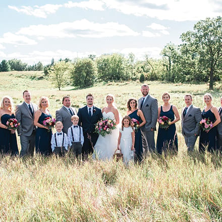 Carrie Seibel and Zach Fisher with their wedding party at St. Anthony on the Lake.