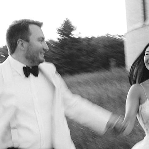 Bride and groom frolick through the grounds outside of Yerkes Observatory hand in hand on their wedding day