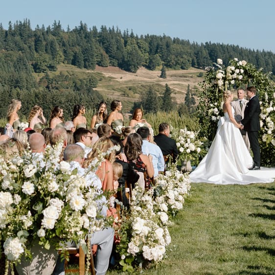 Lindsey and Scott stand at the alter in outdoor ceremony at Chateau de Harpe