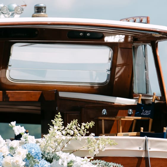 Model poses on a boat decorated in florals floating on Lake Geneva outside of The Abbey Resort