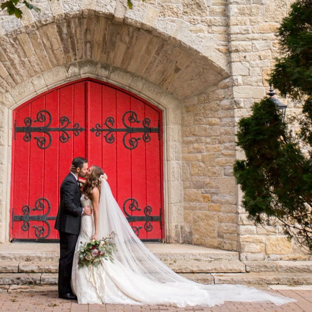 The couple embraces outside the historic stone church at St. John's Military Academy
