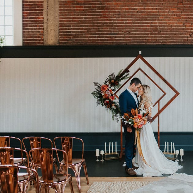 A geometric arch with tropical florals as a ceremony backdrop at The Evergreen in Portland