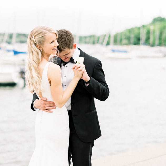 A bride and groom on a lake at their first dance.