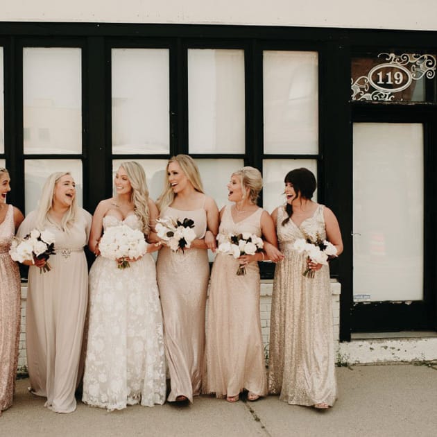 The bride squad, wearing neutrals, walks through Minneapolis.