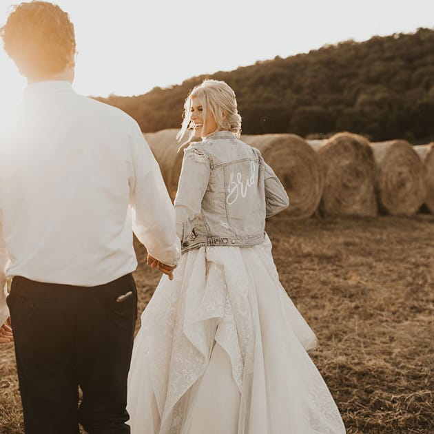 The bride shows her down-home style in a distressed and embellished bridal jean jacket.