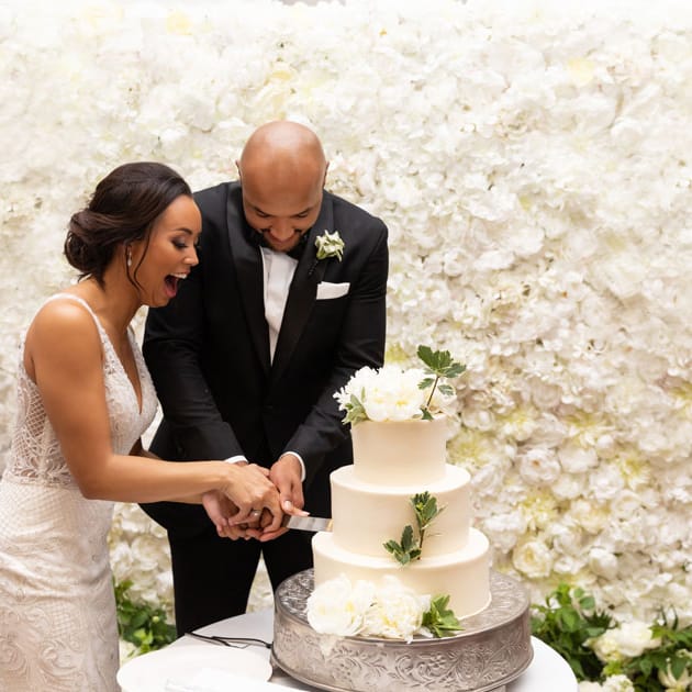 The bride cuts the cake with the groom (former Minnesota Vikings player Michael Floyd).